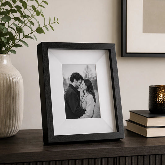 Black box photo frame displaying a family photograph on table