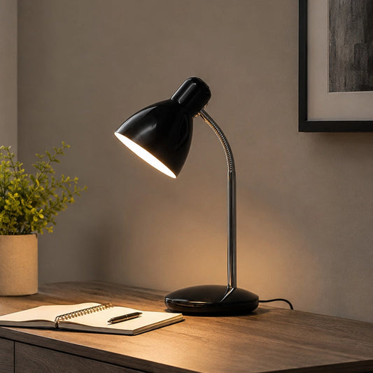 Black desk lamp on study table with notebook and soft warm light