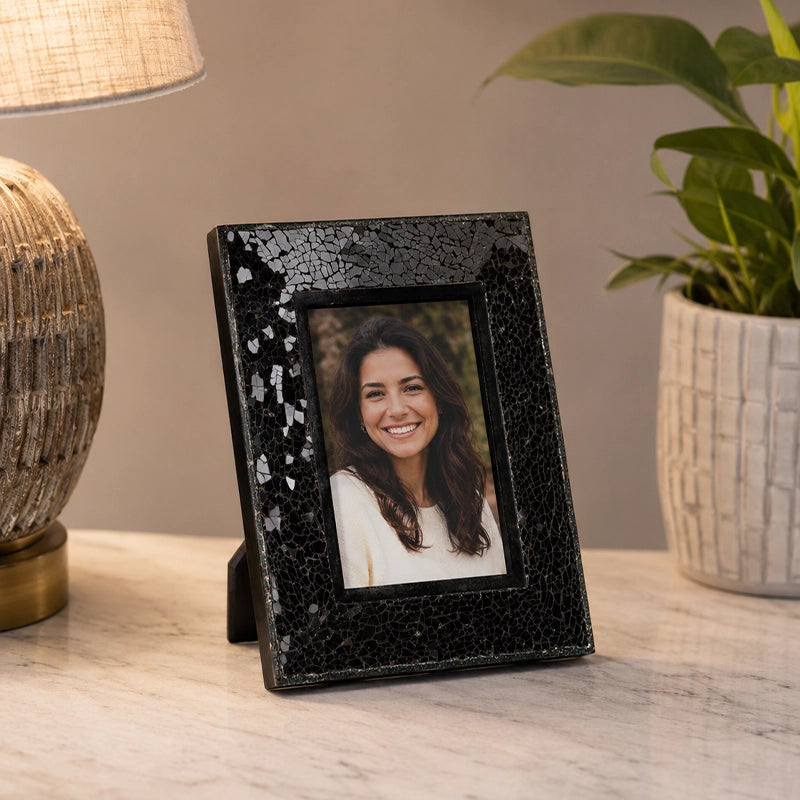 Black table photo frame with decorative finish beside home decor