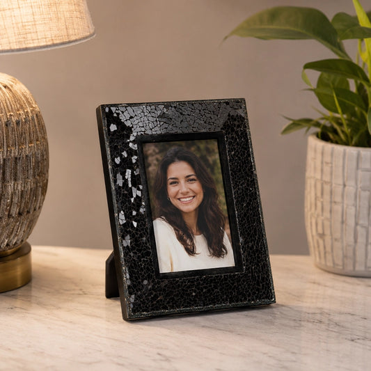 Black table photo frame with decorative finish beside home decor