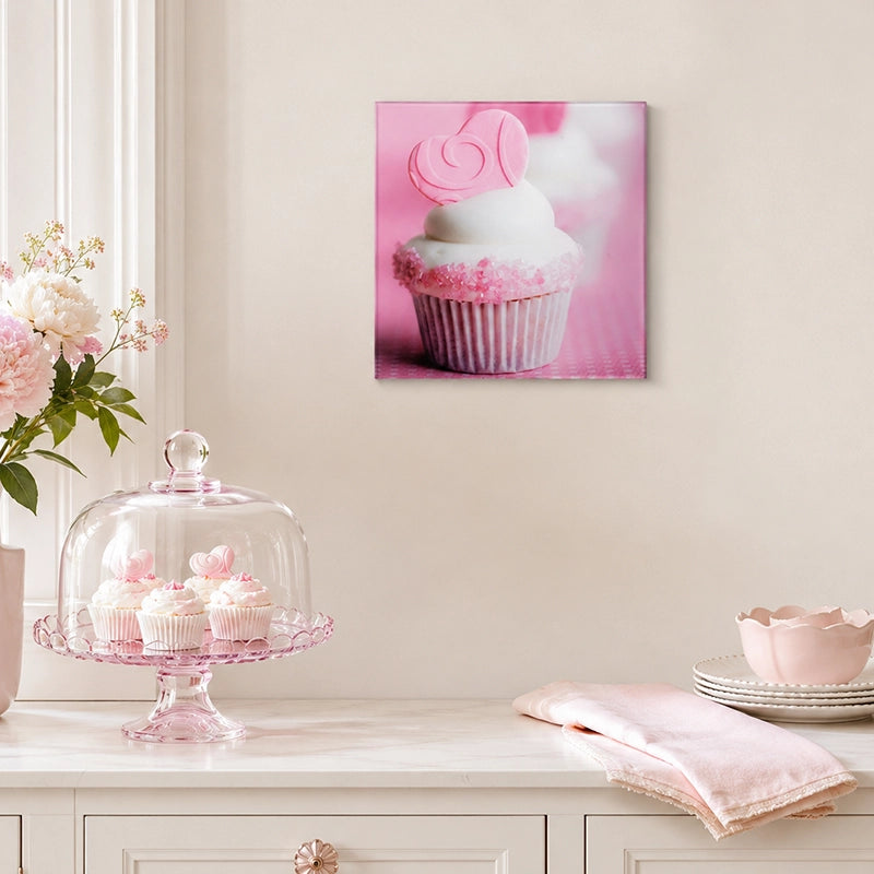 Pink cupcake glass wall art displayed above a white sideboard in a pastel room