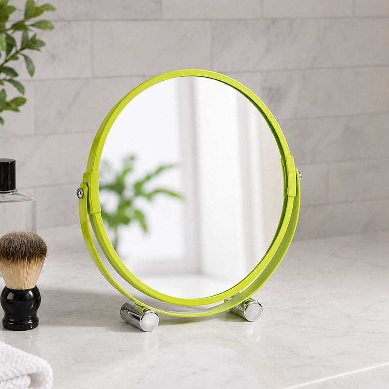 Green shaving mirror with feet on bathroom counter beside toiletries