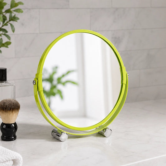 Green shaving mirror with feet on bathroom counter beside toiletries