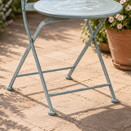 Close-up of grey metal folding garden table legs on outdoor patio