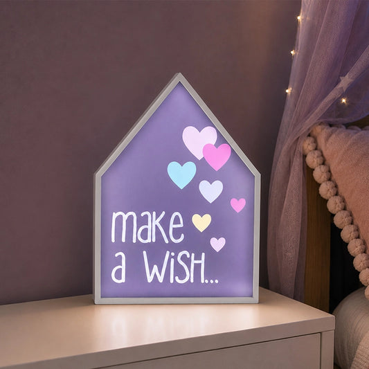 Purple make a wish LED light box with heart design beside children’s bed