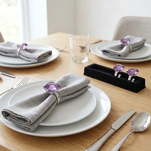 Purple square diamante napkin rings on folded grey linen napkins, elegant dining table setting
