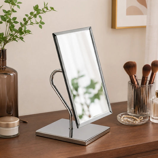 Rectangular table mirror on wooden vanity with makeup accessories