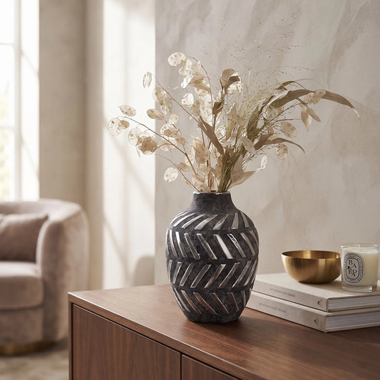 Small dark grey ceramic vase with carved pattern and decorative dried stems