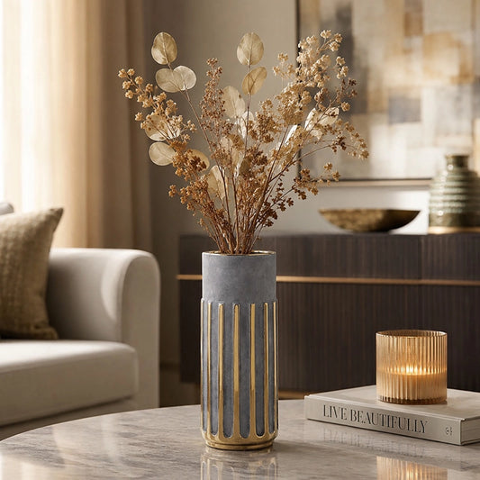 Small grey and gold decorative vase with dried botanical stems on a marble table