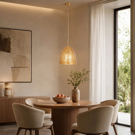 Small gold pendant light hanging above round dining table in modern room
