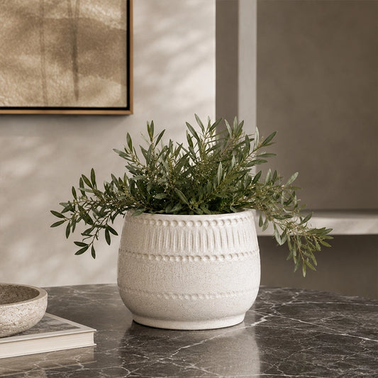 Set of two white planters on a wooden tripod stand with green plants in a modern interior