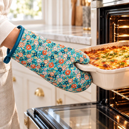Teal floral print single oven glove being used to remove a baked dish from the oven