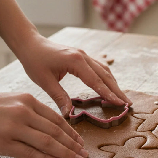 Hands pressing a gingerbread lady cookie cutter into rolled gingerbread dough