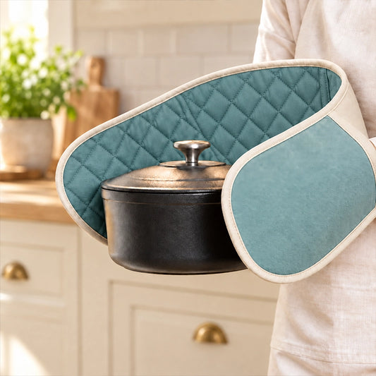 Quilted teal double oven mitt held by a person carrying a pot in a bright kitchen setting
