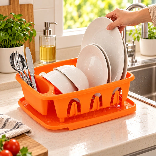 Hand placing a white plate into an orange plastic dish drainer with removable tray on a kitchen countertop