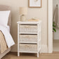White storage unit with three maize baskets beside bed for bedroom organisation