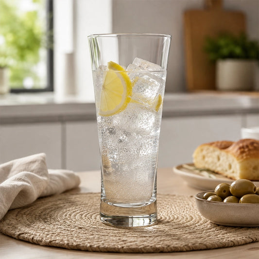 480ml clear highball glass filled with iced lemon water on a kitchen table