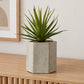 Artificial sword grass plant in a cement pot styled in a clean minimal modern interior