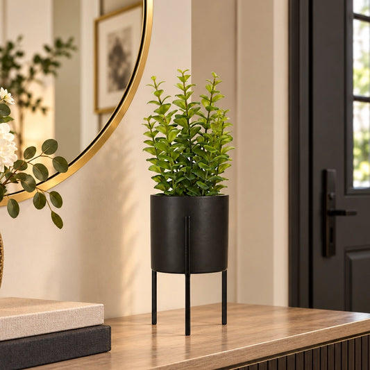 Artificial thyme plant in a tall pot styled against a dark entryway in a modern home interior