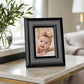 Black 5x7 photo frame with portrait picture displayed on marble surface