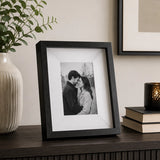 Black box photo frame displaying a family photograph on table