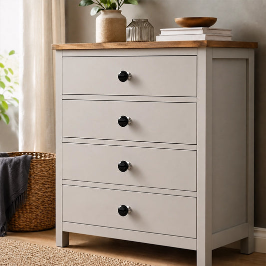Black round drawer knobs fitted to a white wooden chest of drawers