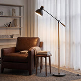 Black floor lamp beside leather armchair in cosy reading corner
