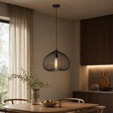 Black metal pendant light with cage shade above dining table
