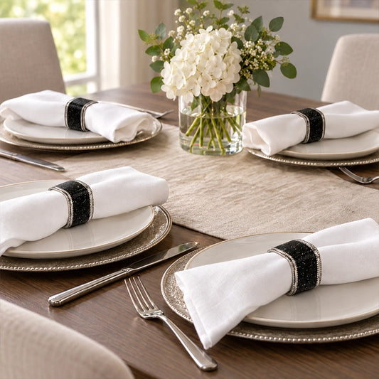 Black napkin rings on white folded napkins in a classic contemporary table setting