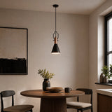 Black pendant lamp with wooden detail hanging above round dining table