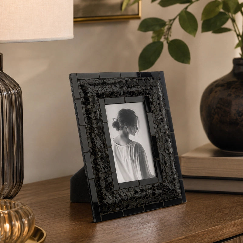 Black picture frame with embossed border on wooden console table