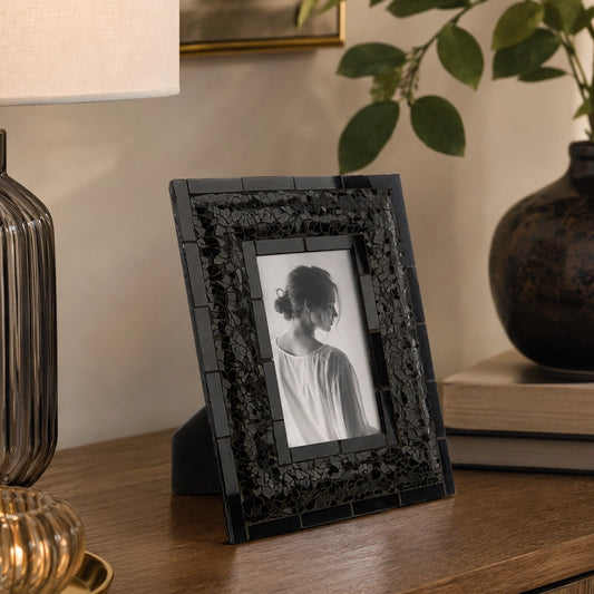 Black picture frame with embossed border on wooden console table