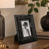 Black picture frame with embossed border on wooden console table