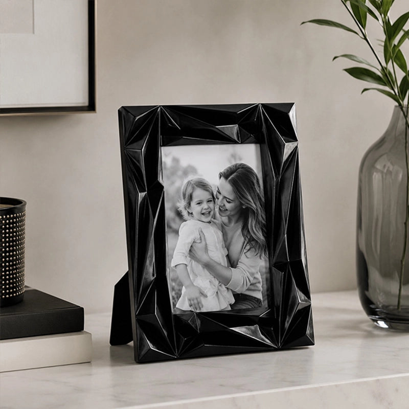 Black plastic picture frame with modern design on marble surface