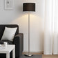 Black shade floor lamp beside sofa and white side table