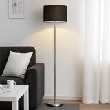 Black shade floor lamp beside sofa and white side table