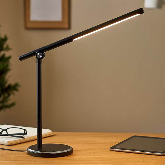 Black touch desk lamp with slim LED bar on wooden desk beside tablet and glasses