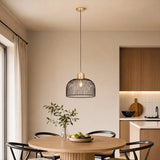 Black and brass pendant light above dining table in modern room