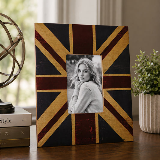 Black and gold photo frame with portrait picture beside plant and books