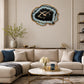 Black and gold wall clock above sofa with cushions in modern lounge