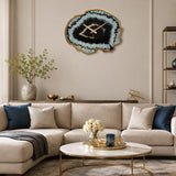 Black and gold wall clock above sofa with cushions in modern lounge