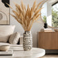 Black and white patterned ceramic vase with tall dried pampas grass in a modern living room