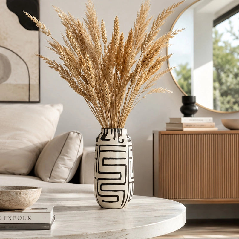 Black and white patterned ceramic vase with tall dried pampas grass in a modern living room
