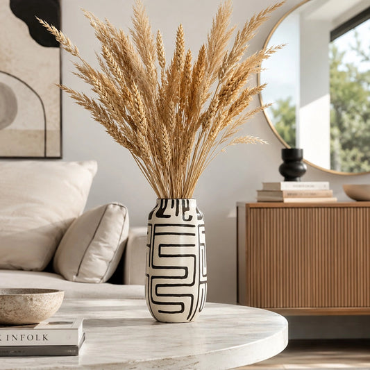 Black and white patterned ceramic vase with tall dried pampas grass in a modern living room