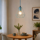Blue wireframe pendant light with exposed bulb above round dining table