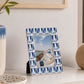 Blue photo frame with patterned border displaying landscape photograph