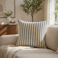 Blue and white striped decorative cushion styled on a neutral armchair