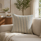 Blue and white striped decorative cushion styled on a neutral armchair