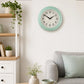 Pale blue wall clock above sofa with soft cushions and home decor