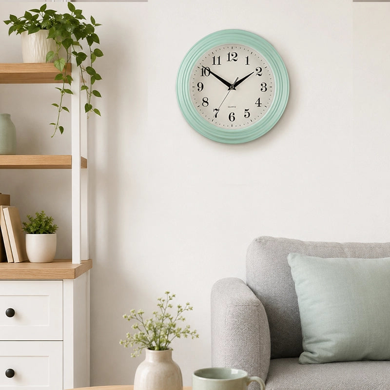 Pale blue wall clock above sofa with soft cushions and home decor